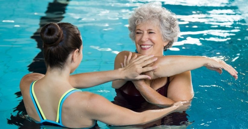 young-instructor-elderly-student-pool